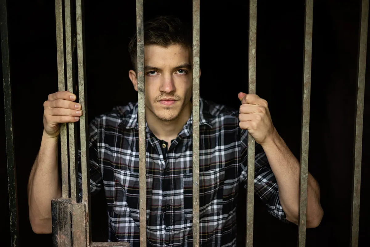 Schauspielportrait Jannik Becker greift Gitterstäbe, Remseck am Neckar.